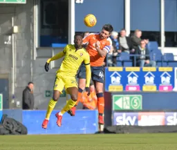 Alan Sheehan rises above Mo Eisa to head the ball clear