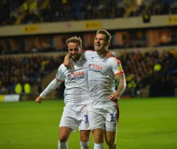 Andrew Shinnie and James Collins embrace in celebration