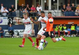 Ryan Tunnicliffe competing in midfield with a backtracking Ashley Fletcher