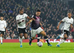 Matty Pearson charges through, bringing the ball out from defence