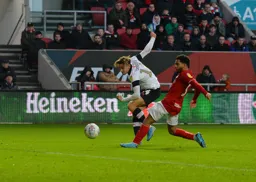 Harry Cornick sending in a shot being watched by former Hatter Jay DaSilva