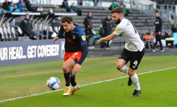 Harry Cornick tight against the touchline is challenged by Graeme Shinnie