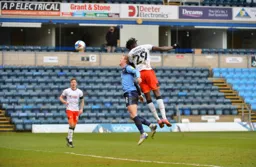 Elijah Adebayo climbs above Jason McCarthy to head in the third goal