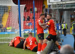 The players come to celebrate with Luke Berry after he levels the match deep in added time