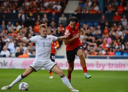 Harry Cornick trying to ride a challenge from former Hatter Flynn Downes