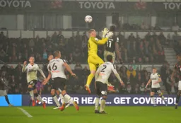 Elijah Adebayo wins his aerial battle against the keeper to score