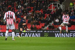 Jordan Clark shoots as Lewis Baker braces himself for impact