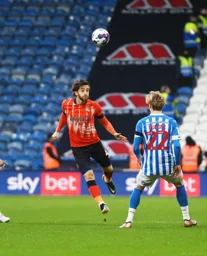 Tom Lockyer heads the ball over Jack Rudoni