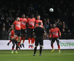 MAN PHOTO The ball sails over the defensive wall from a Grimsby free kick