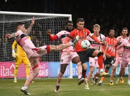 Dan Potts is outnumbered with his back to the Grimsby goal