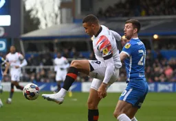 Carlton Morris controls the ball under pressure from Gary Gardner