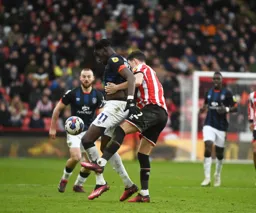 Eiljah Adebayo shields the ball from John Egan
