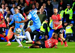 Pelly Ruddock-Mpanzu on the ground tackles Pierre Ekwah