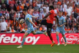 Elijah Adebayo juggles the ball past Luke McNally