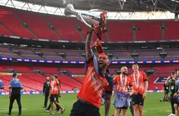 Henri Lansbury shows off the trophy