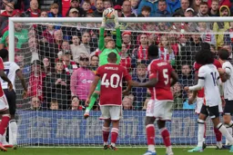 Thomas Kaminski takes the ball from under the bar