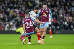 Andros Townsend glides between two Burnley players