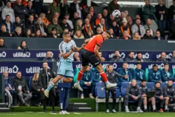 Carlton Morris stretching his neck to head the ball forward